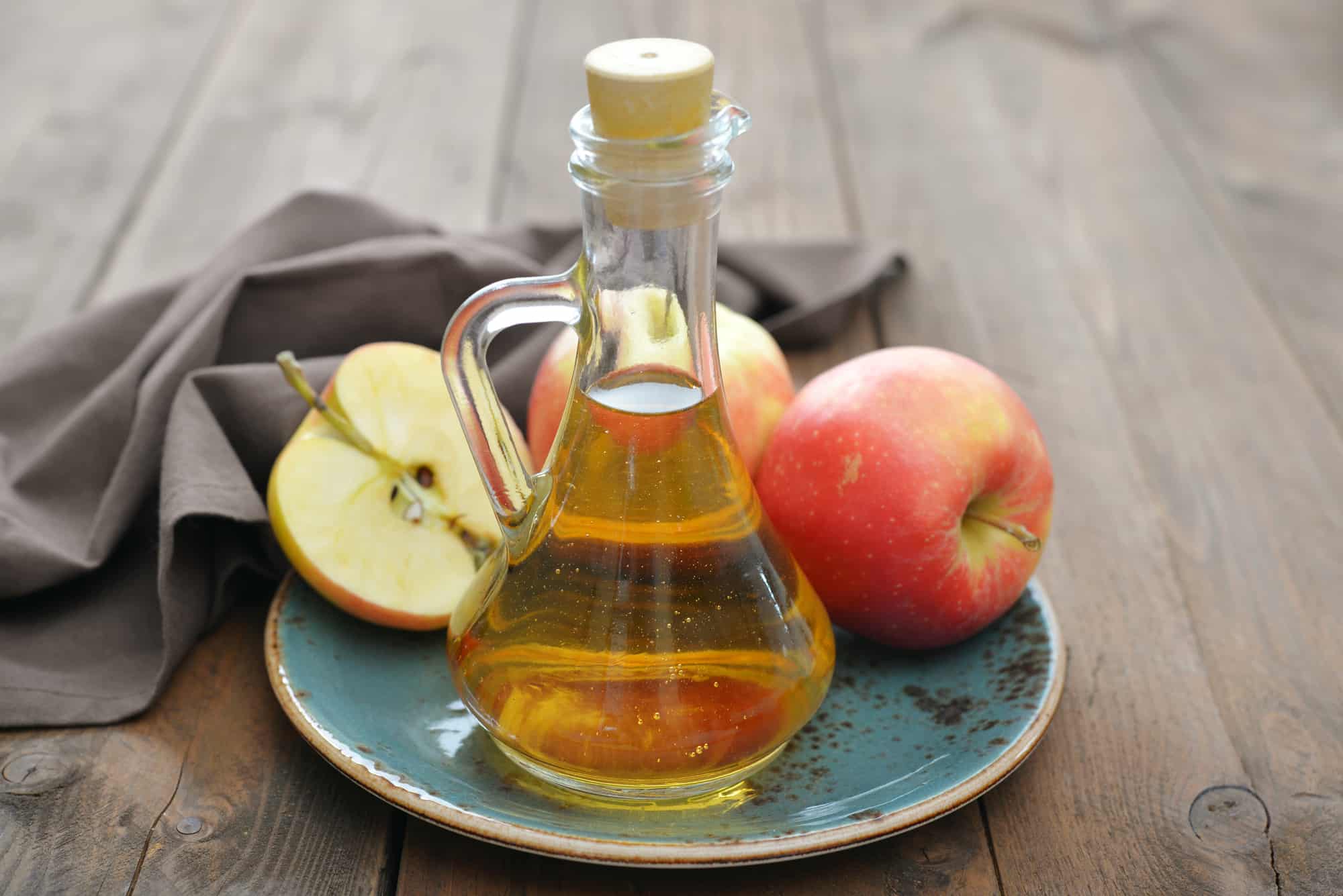 Apple cider vinegar in glass bottle and fresh apples