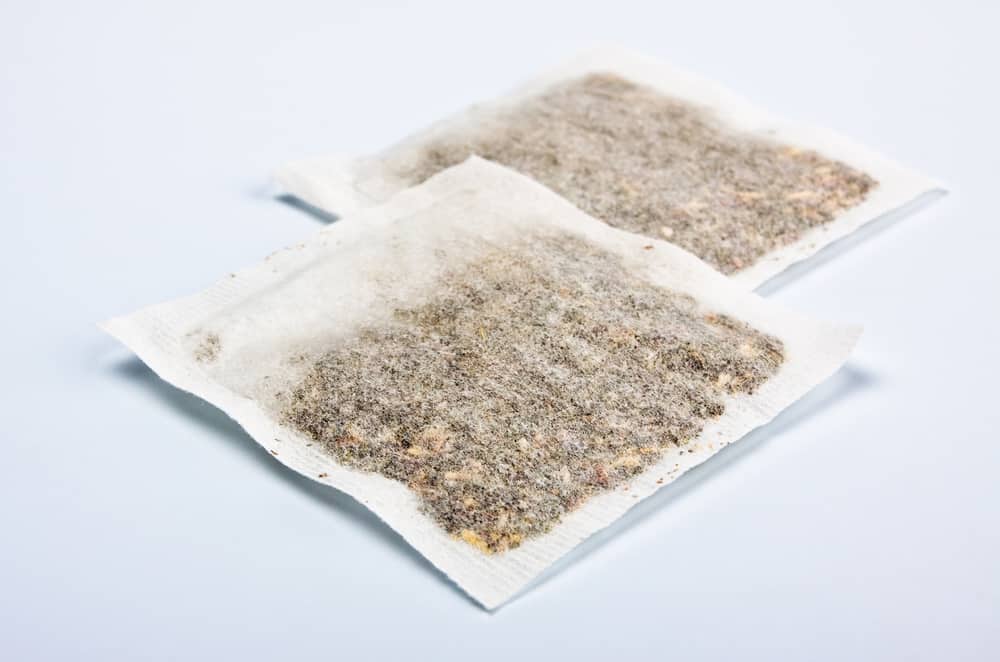 herbal tea bags laying on table, blue background