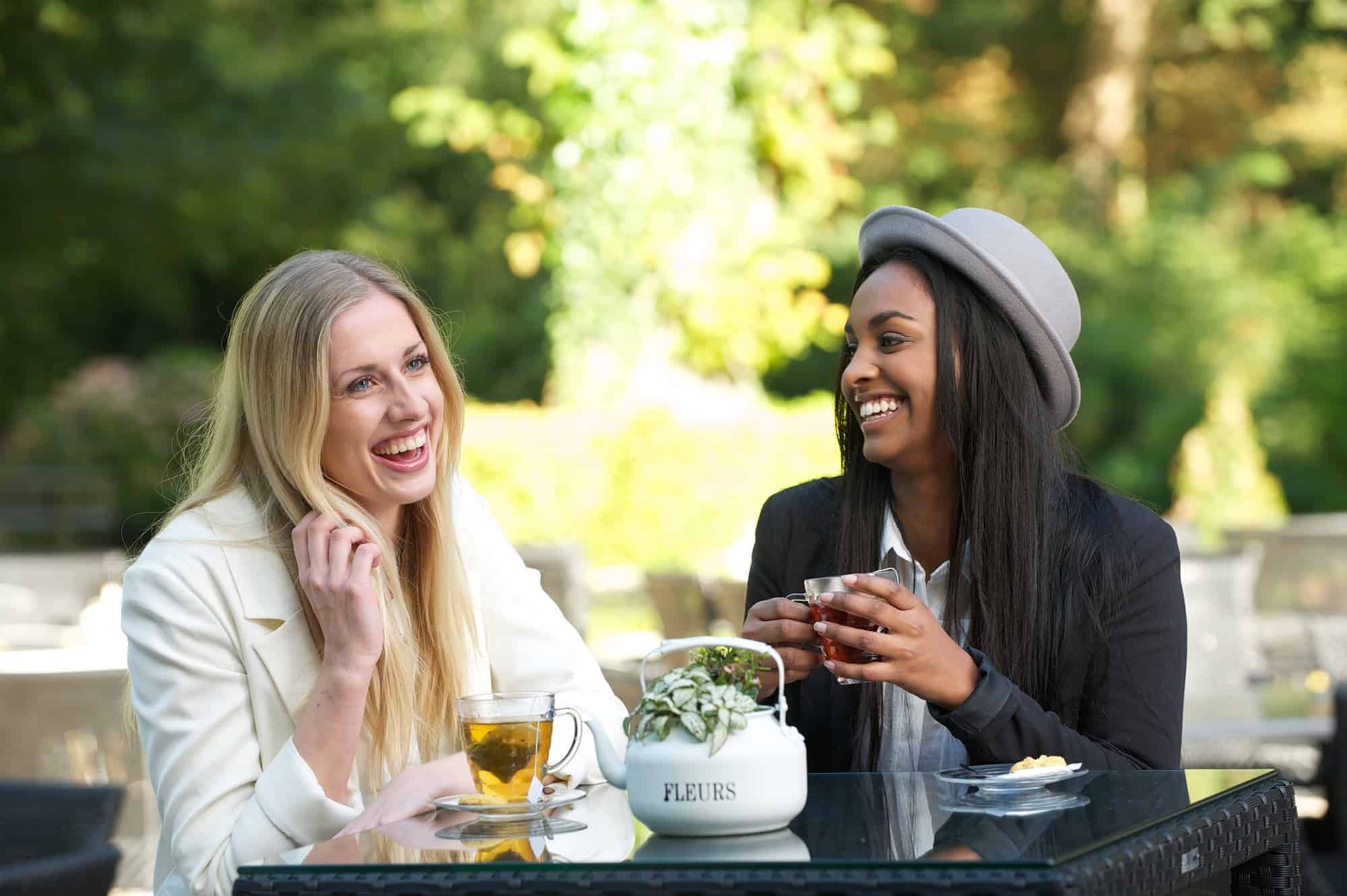 multicultural friends drinking tea and smiling