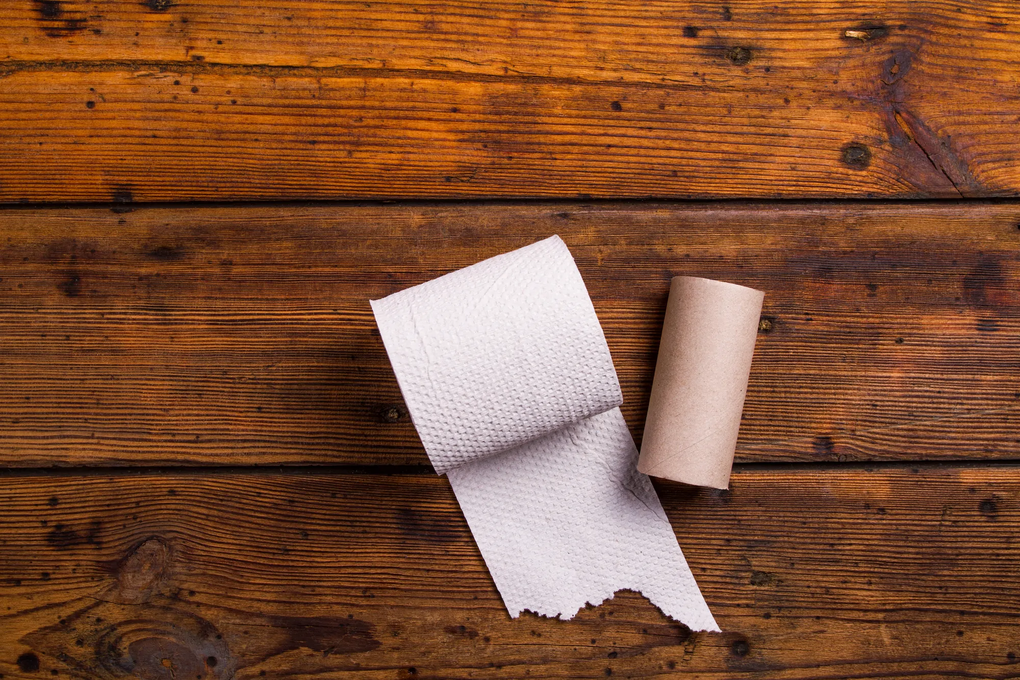 Toilet paper against wood flooring