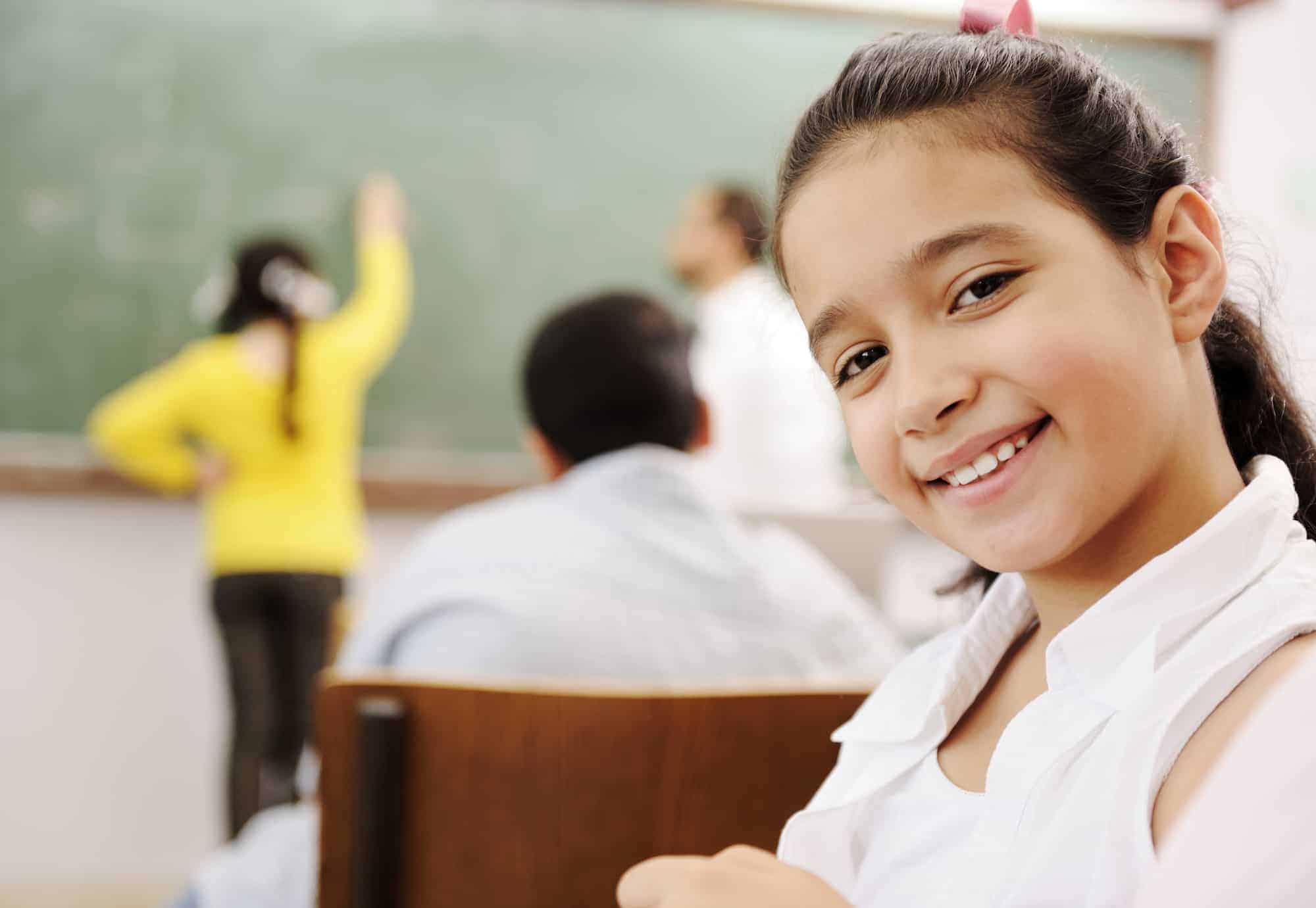 Adorable girl smiling in school classroom