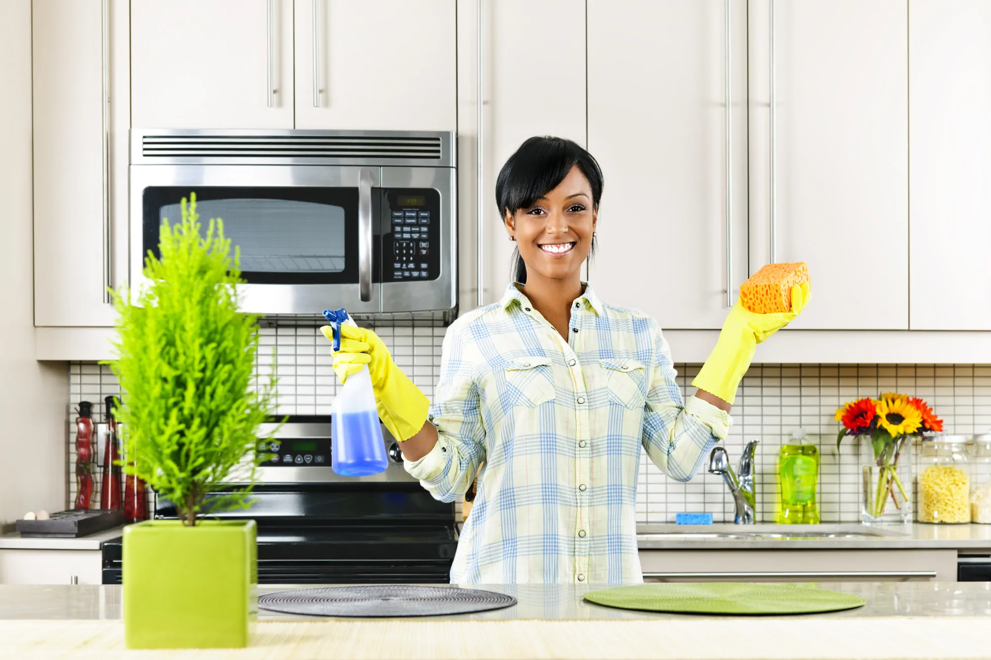 young black woman cleans kitchen with non-toxic cleaner