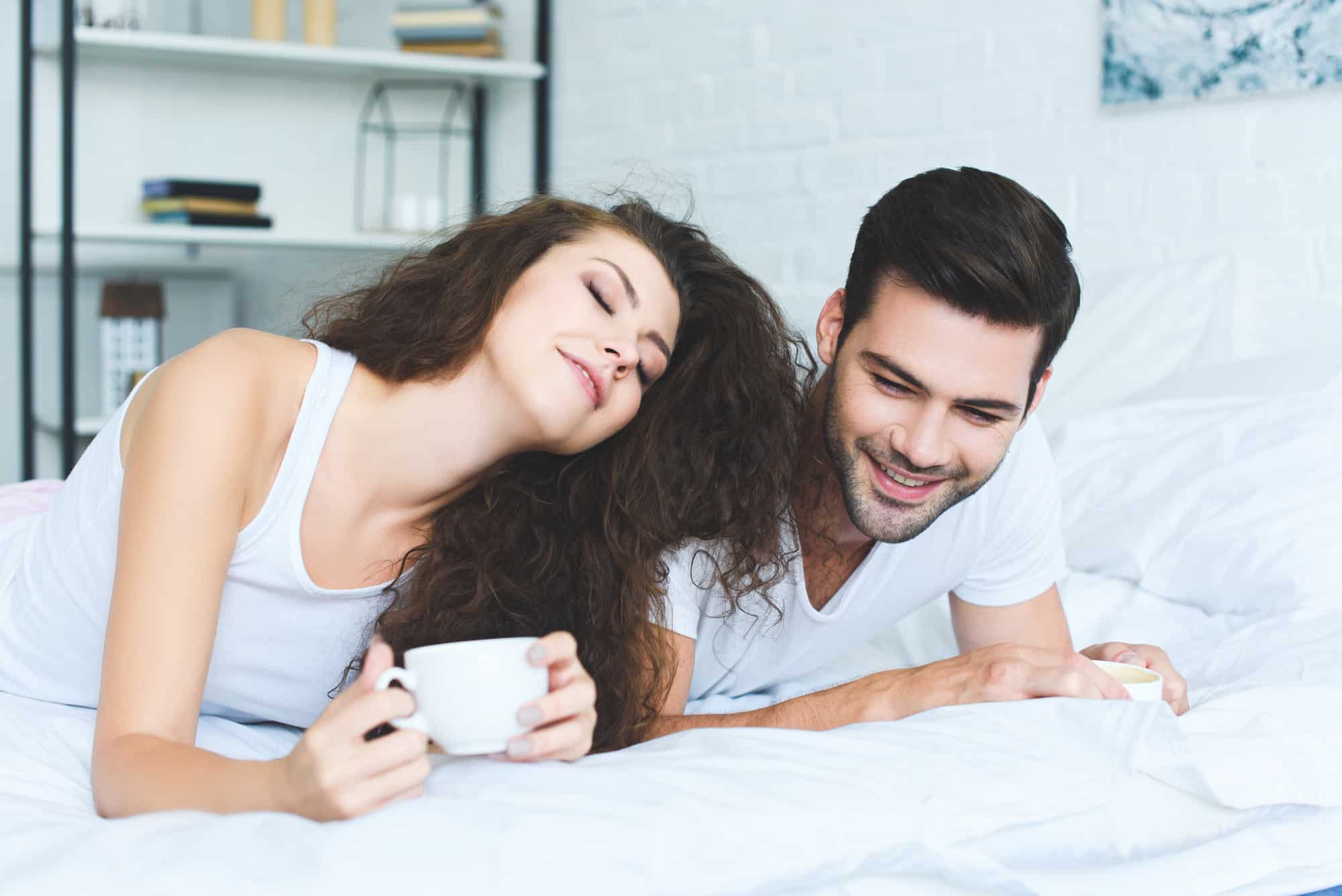 woman and man on the bed enjoying organic coffee