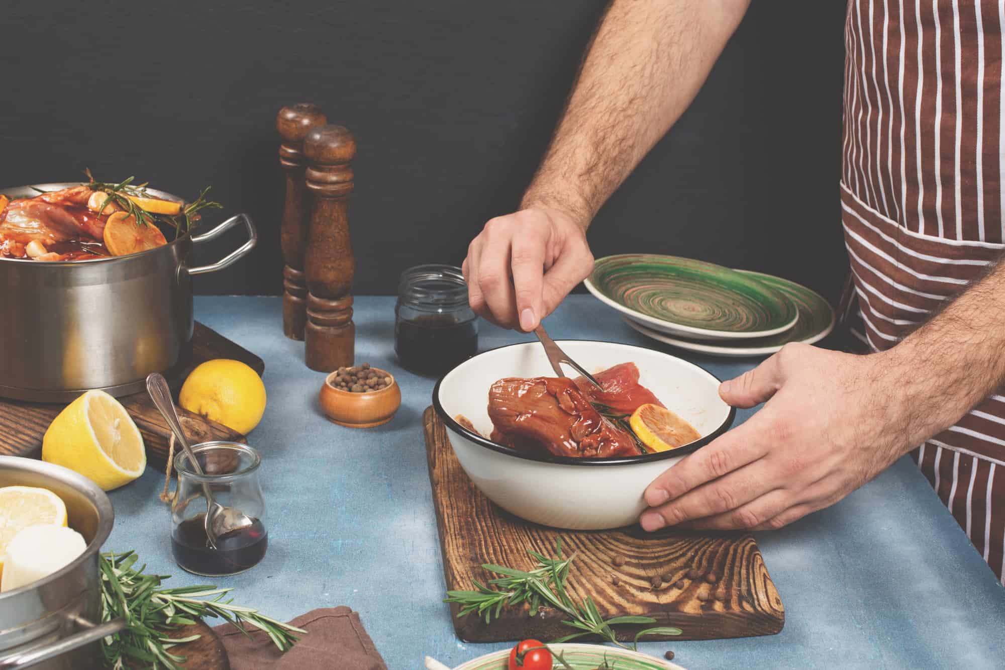 Close up photo of man's hands who marinades beef for stewing