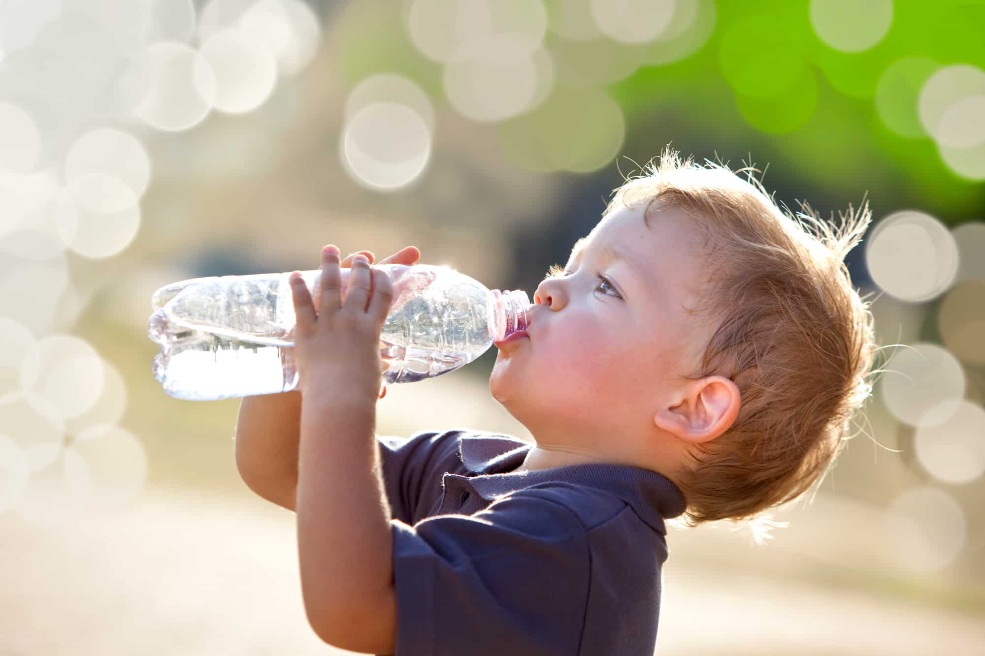 beautiful blonde child drink water outdoor