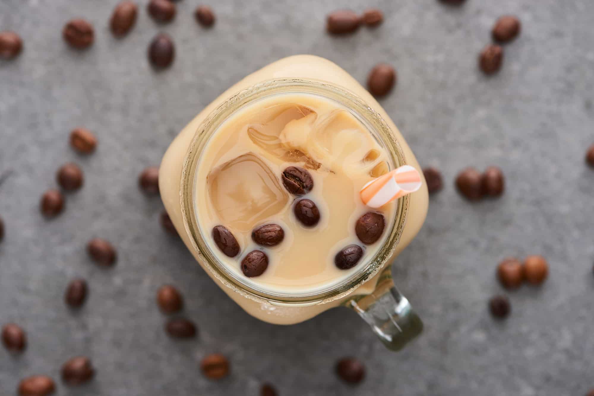 Coffee Iced in a glass with coffee beans all around