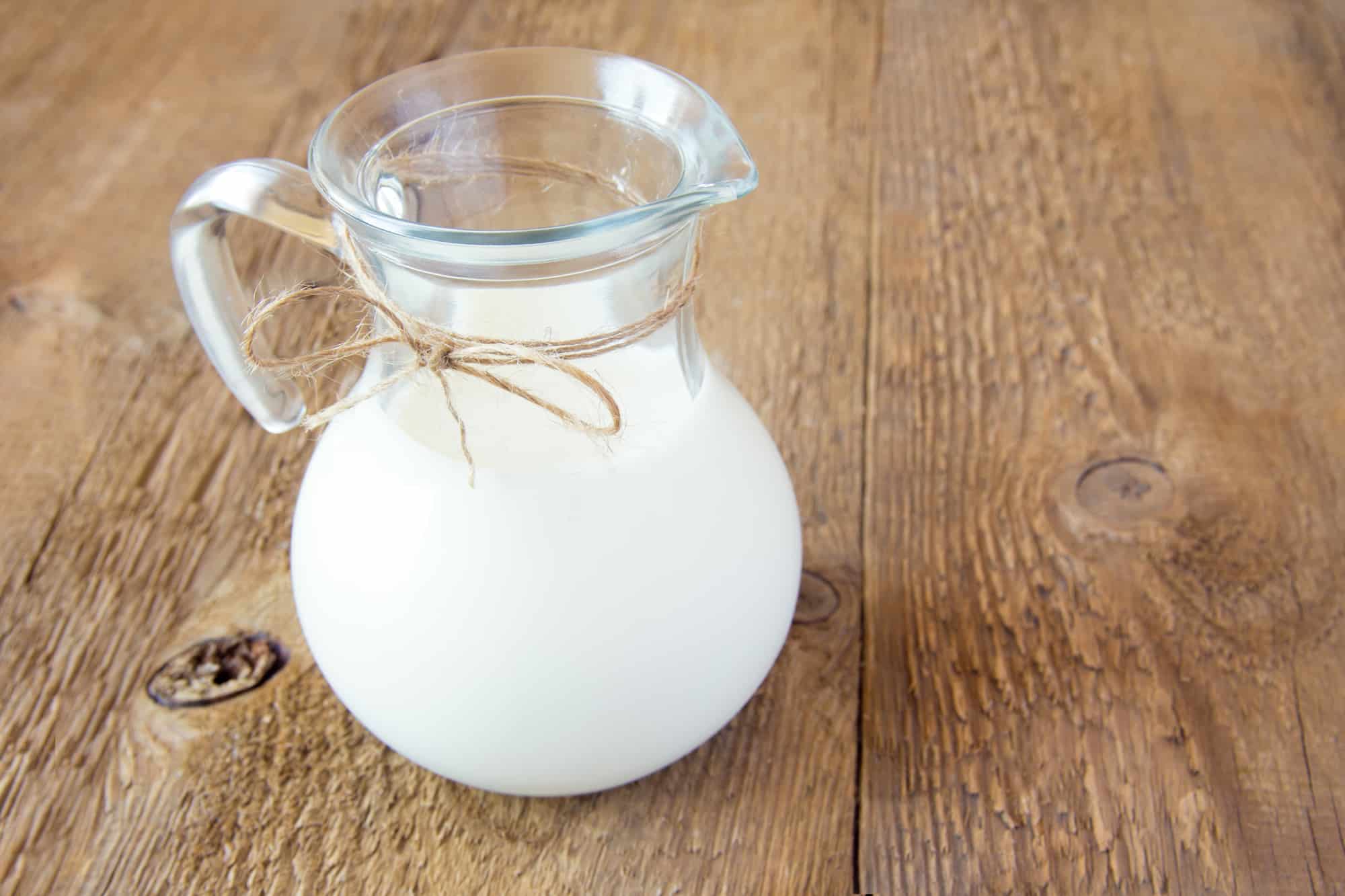 Milk in glass jar on rustic wooden table
