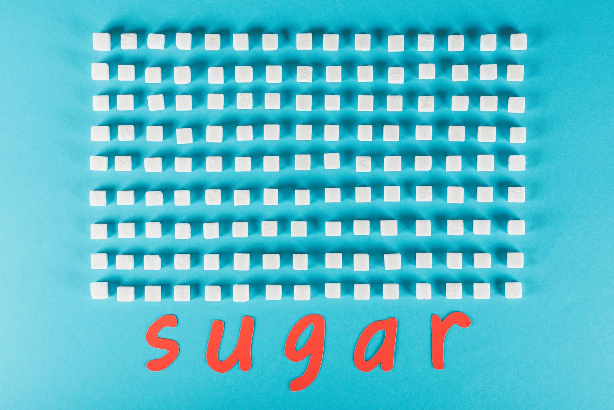 hundreds of sugar cubes laid out on a blue table