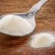 collagen protein powder on a tablespoon against rustic wood