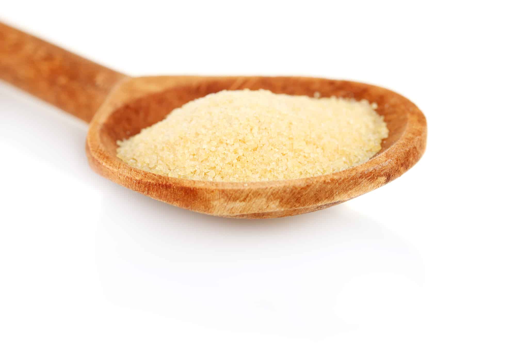 Gelatin in a wooden spoon on white background close-up