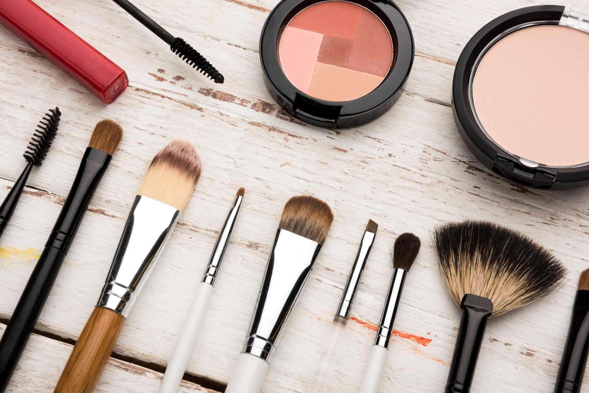 makeup brushes on white wooden table