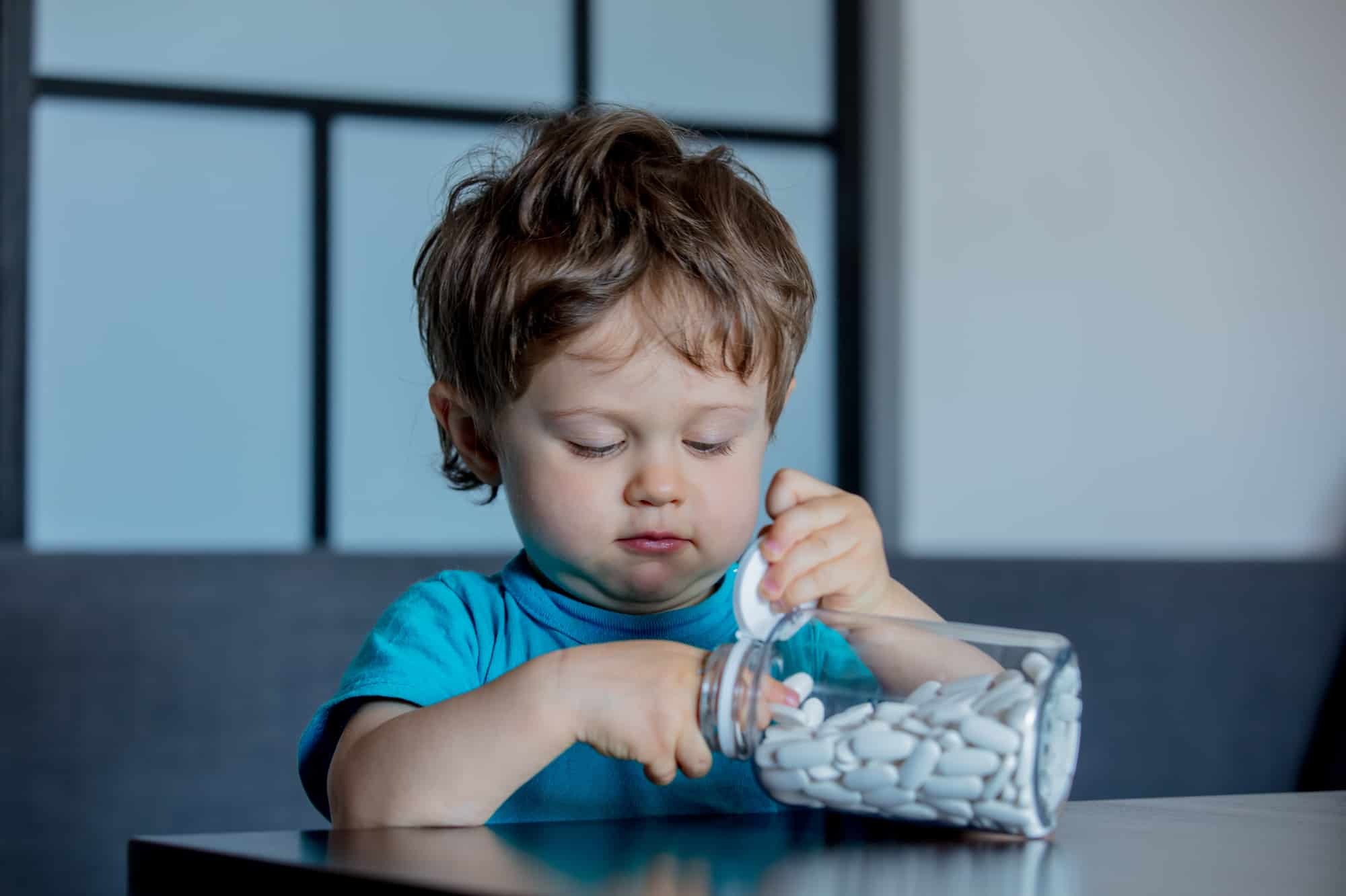 little toddler boy try to get the pills out of the jar