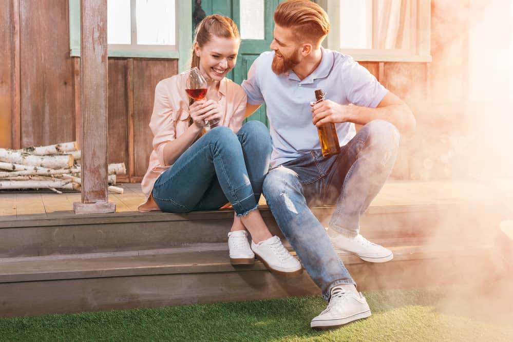 couple drinking on steps outside in summer