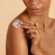 Skin care. Closeup woman's body with cosmeticBeautiful black girl with moisturizing lotion on hydrated body skin