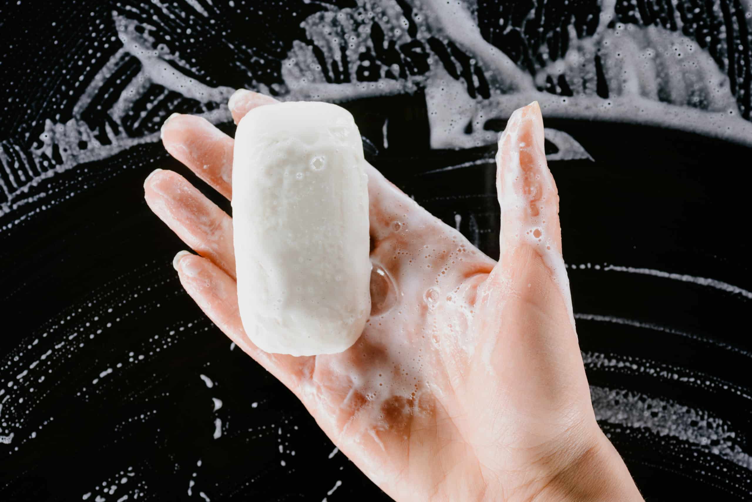 woman holding soap in the shower