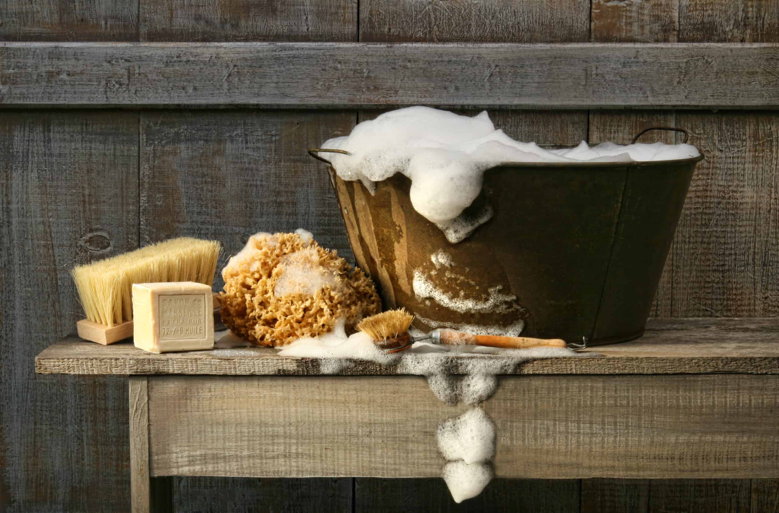 Old wash tub with soap on rustic bench