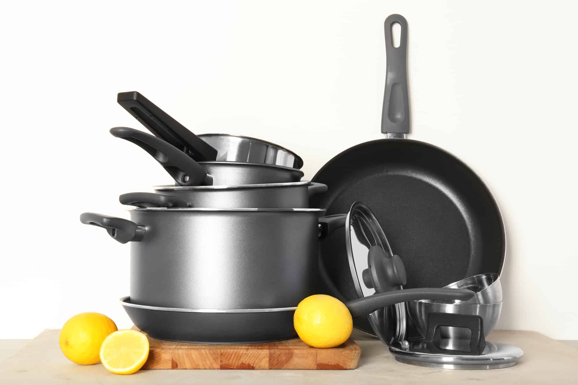 Kitchenware prepared for cooking classes on table against white wall