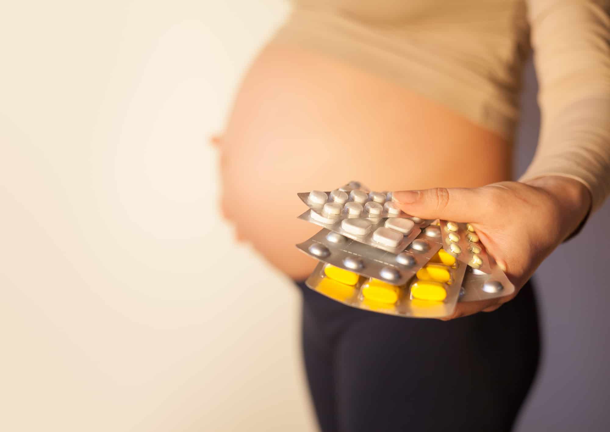Pregnant woman uses vitamin tablets for healthy nutrition