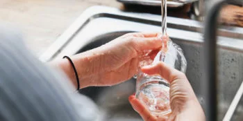 woman washing glass with non-toxic dish soap