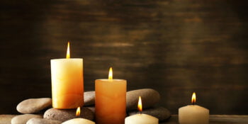 Beautiful composition with candles and spa stones on wooden background