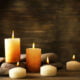 Beautiful composition with candles and spa stones on wooden background