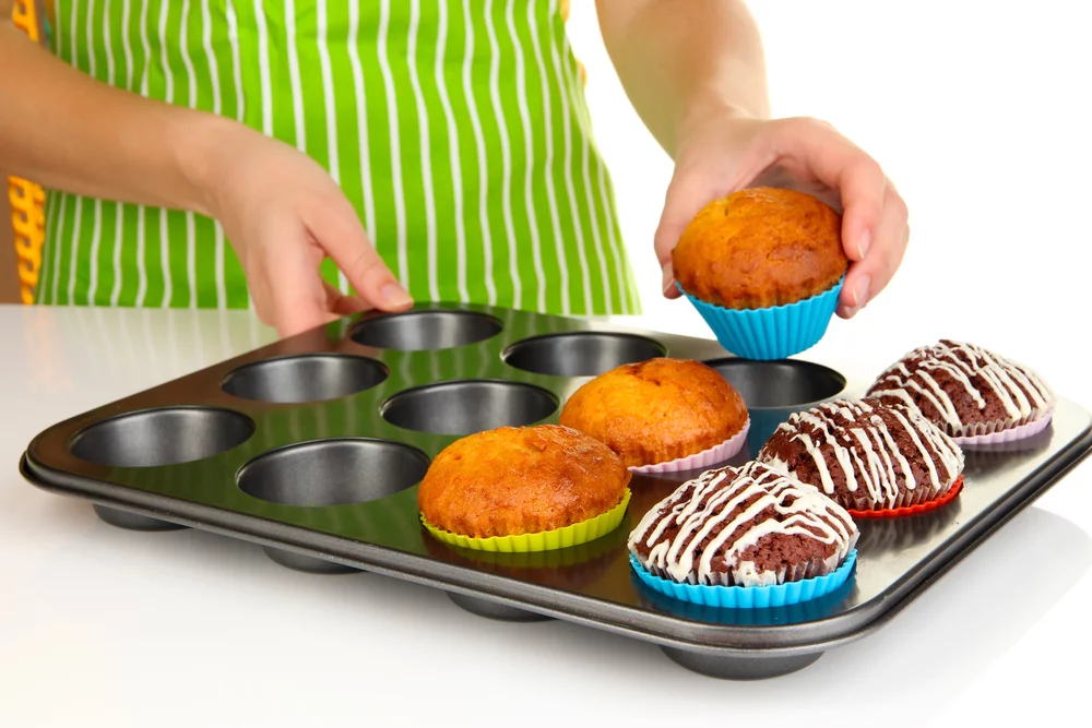 Preparing tasty muffin cakes close up on nonstick bakeware
