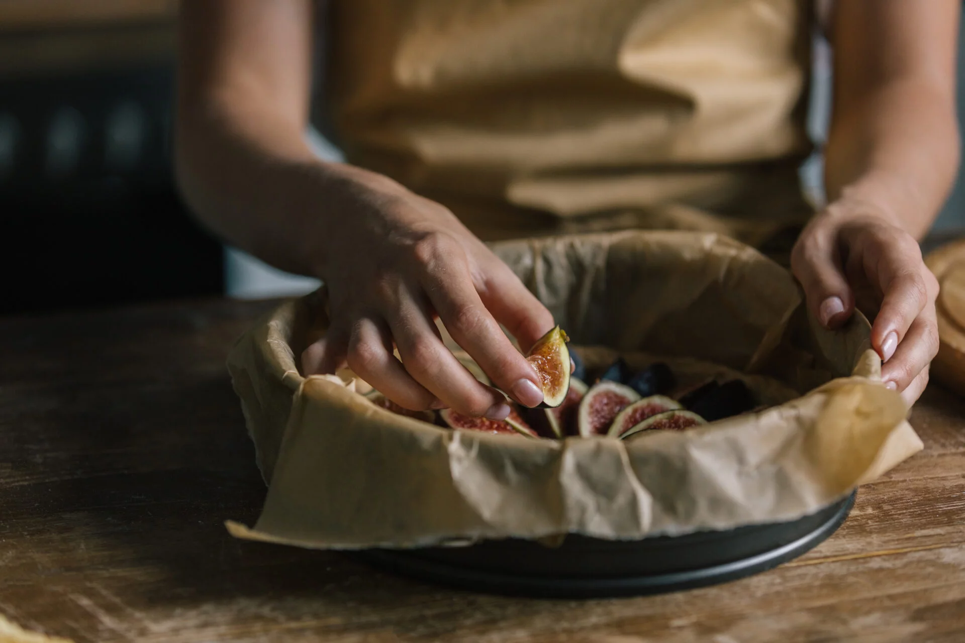 woman puts figs inside pie with parchment paper