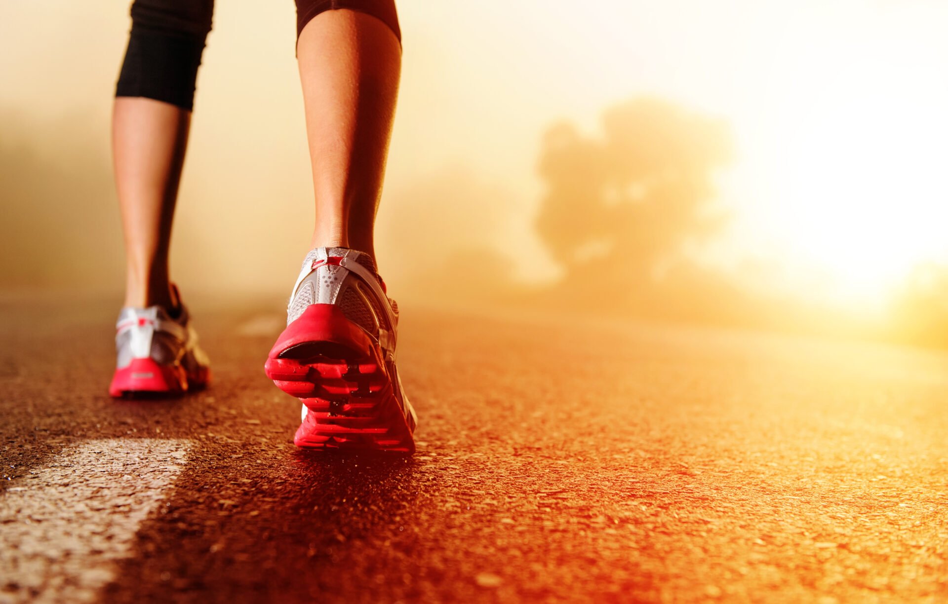Athlete runner feet running on road closeup on shoe. woman fitness sunrise jog workout 