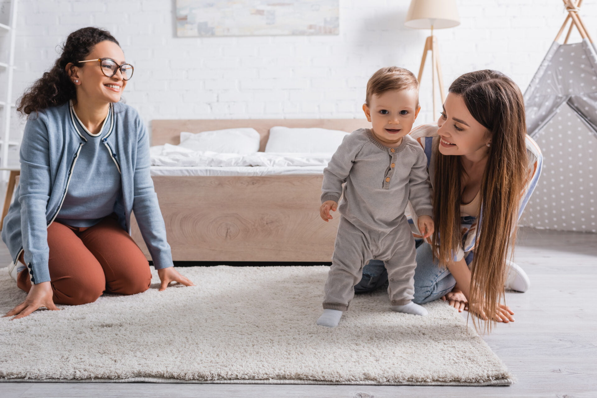 family with toddler walking on light colored carpet