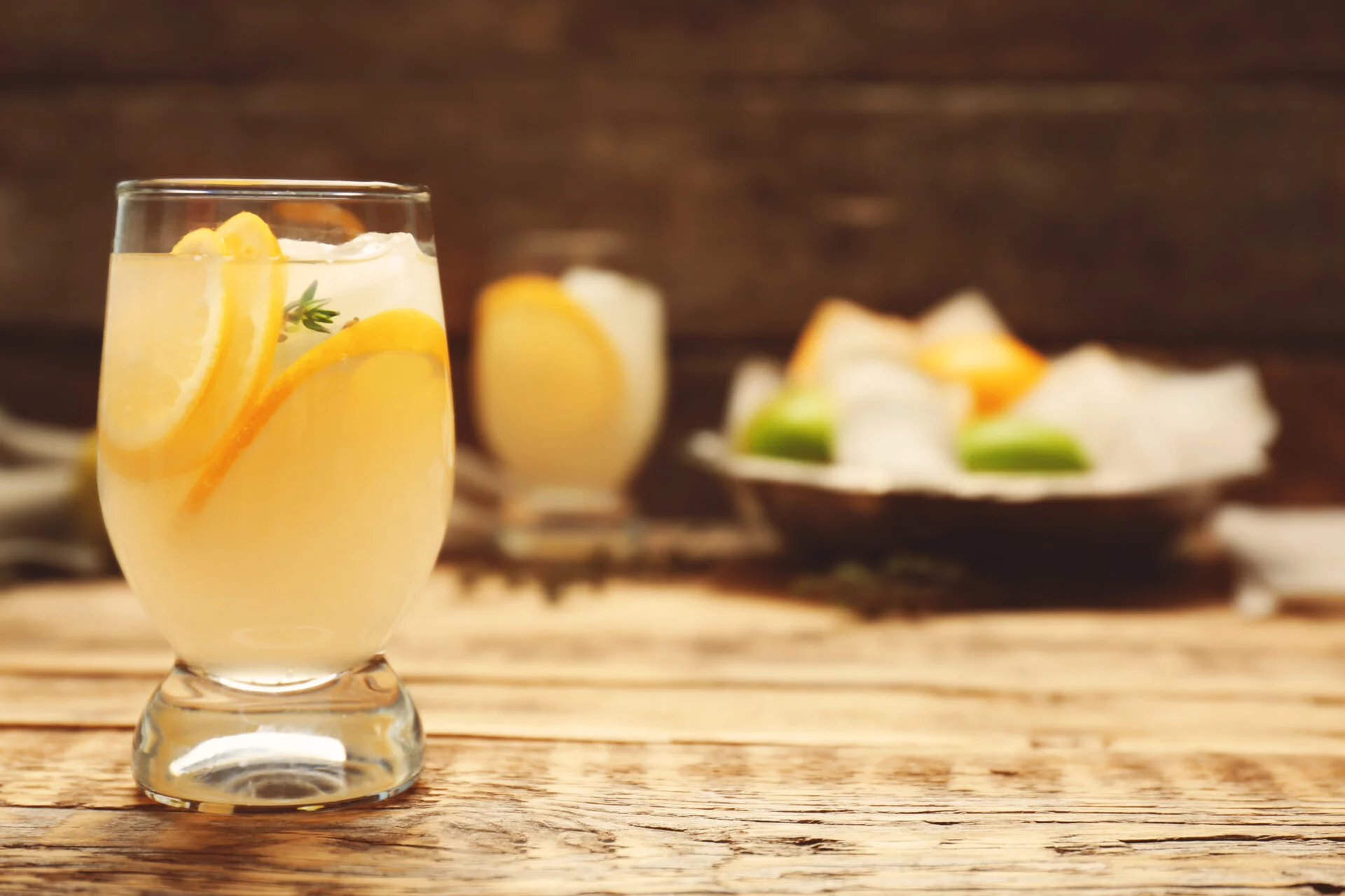 Refreshing cocktail with lemon on wooden table