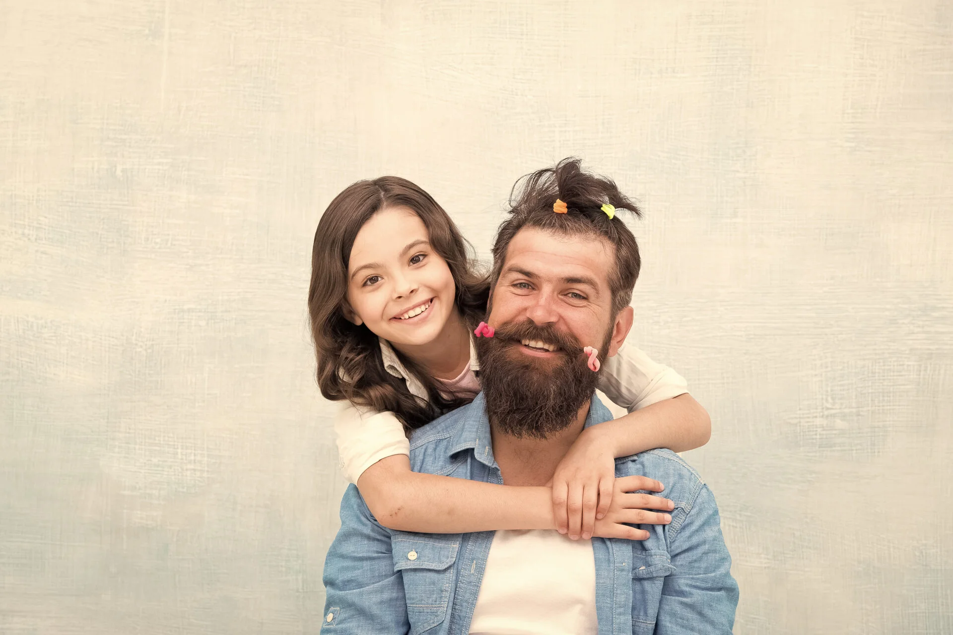 daughter gives bearded daddy a ponytail