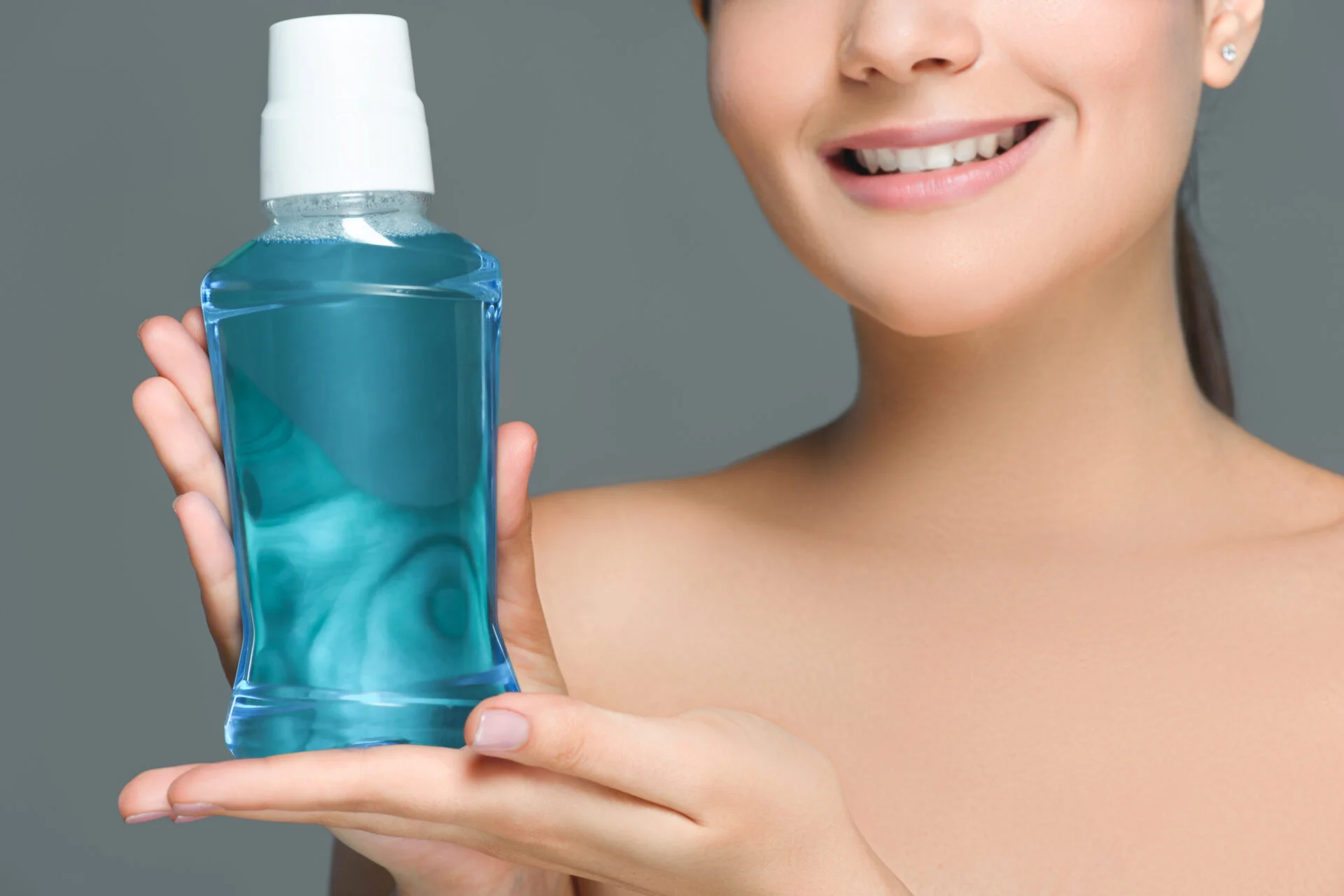Woman holding up mouthwash with toxic ingredients