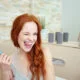 Playful redhead brushing her teeth