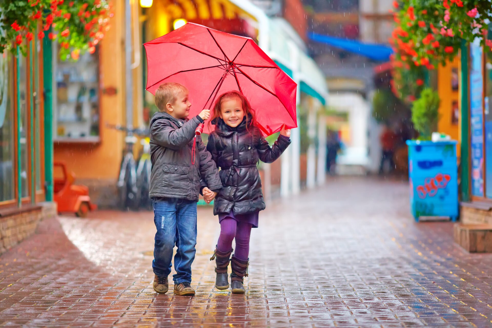 happy kids walking under the rain on colorful street with PFAS free jackets