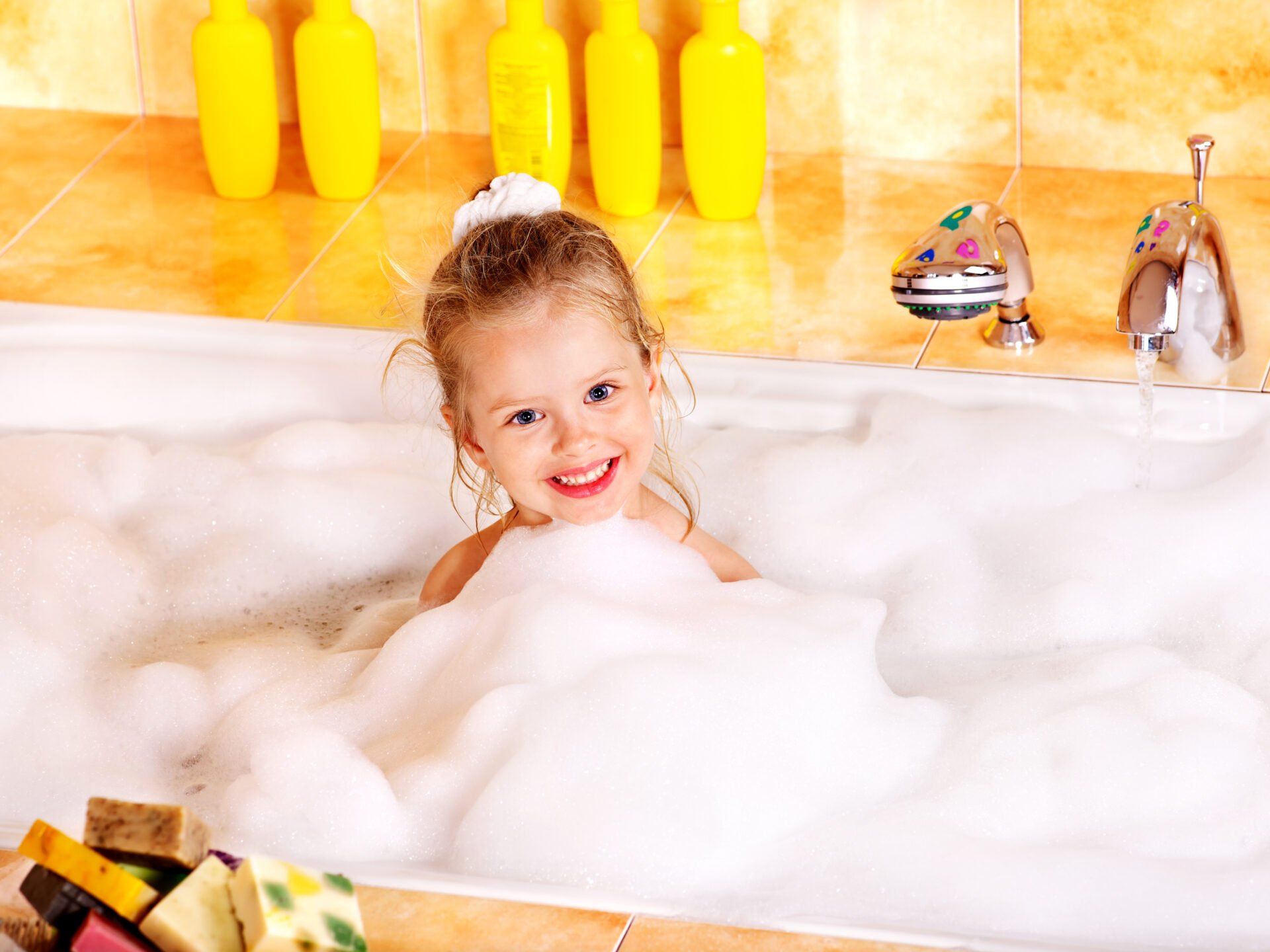 Happy little girl washing in non-toxic bubble bath 