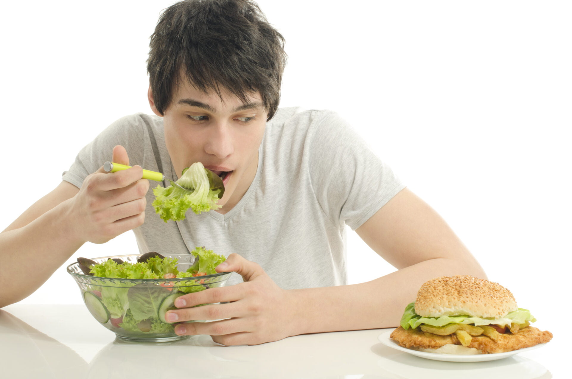 young man eating salad instead of fast food