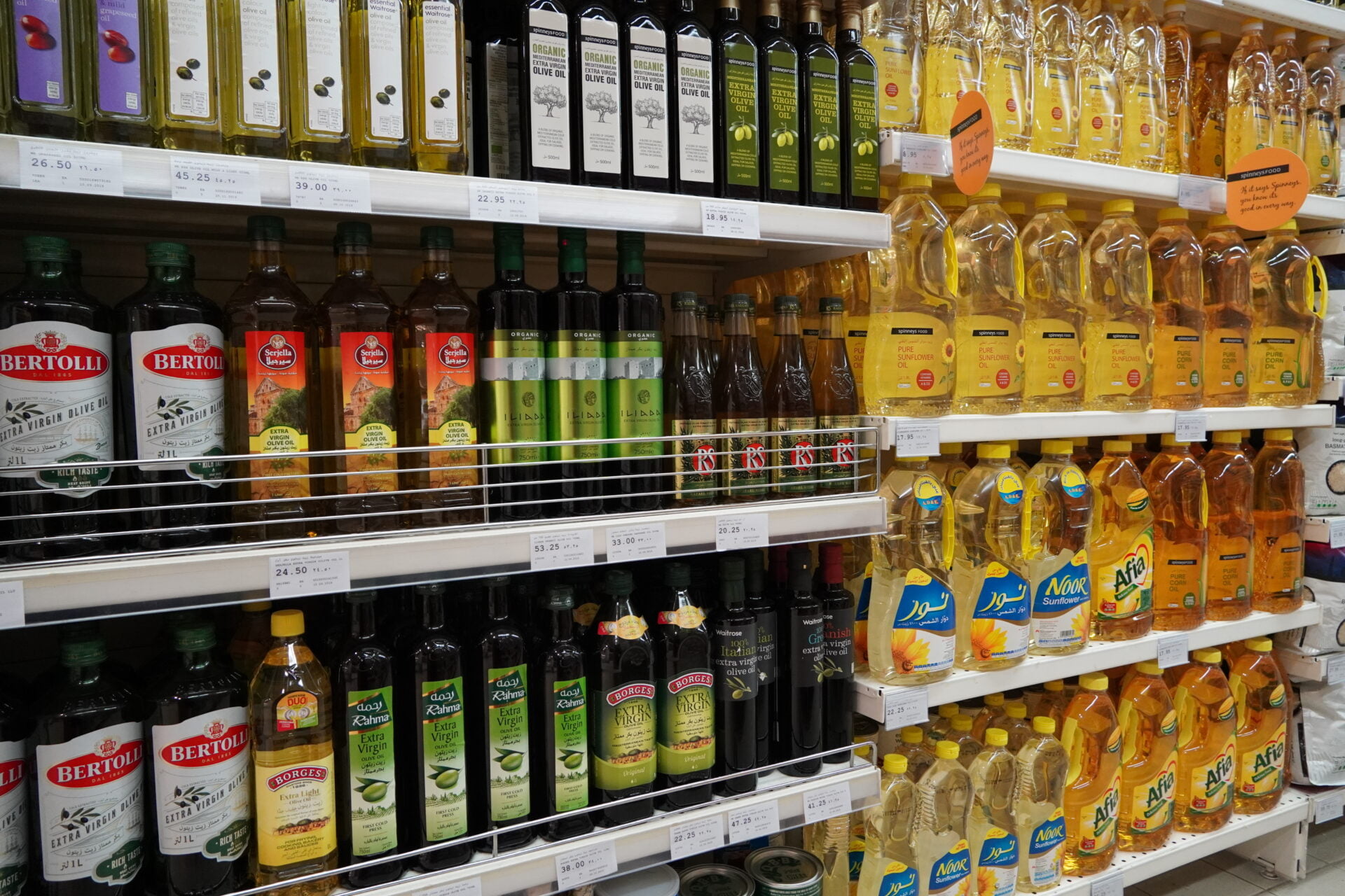 Bottles of cooking oils for sale. Corn, sunflower, extra virgin olive oils. Rows of high quality healthy cooking oil. Variety brand of cooking oil on display rack