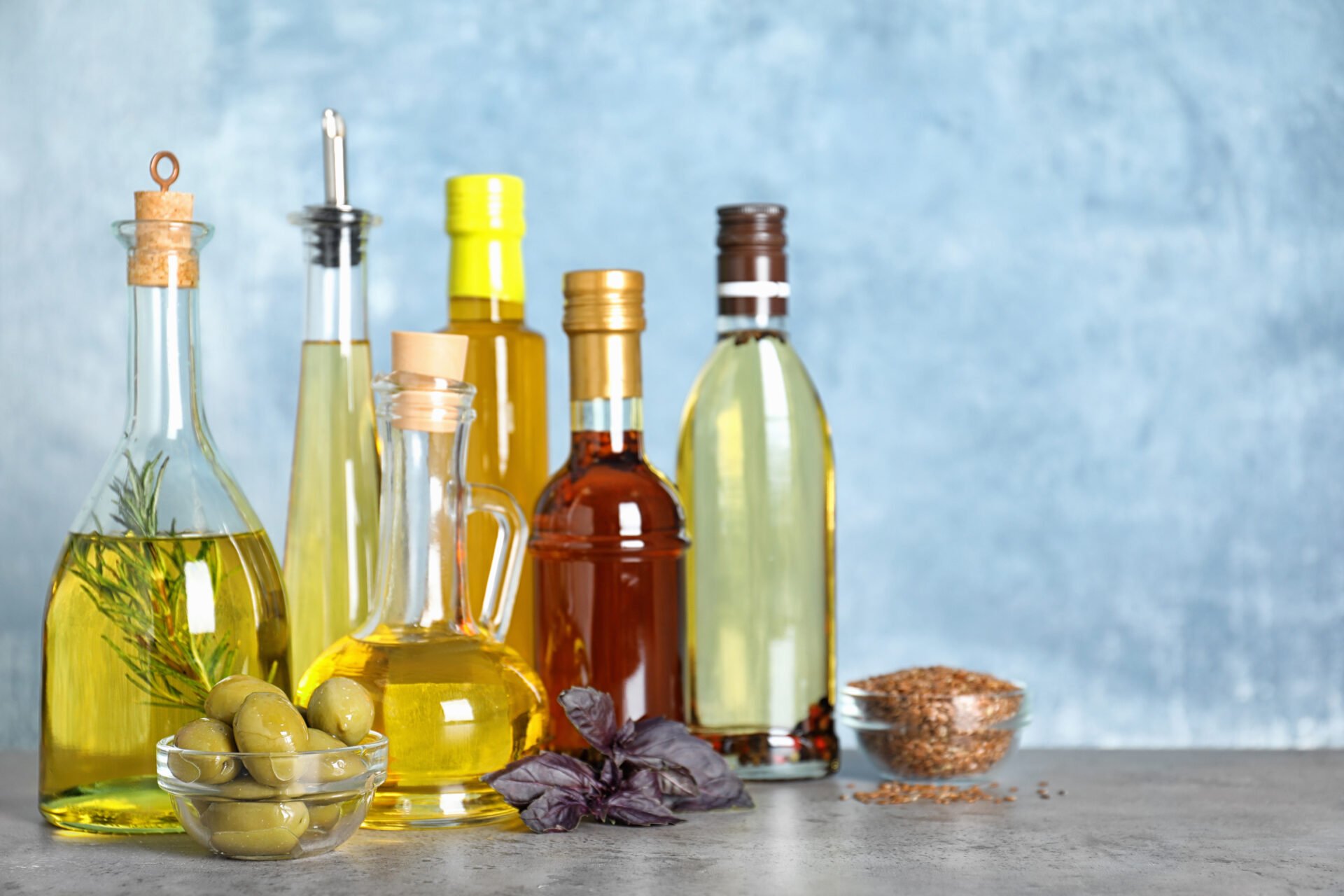 Different cooking oils in bottles on grey table