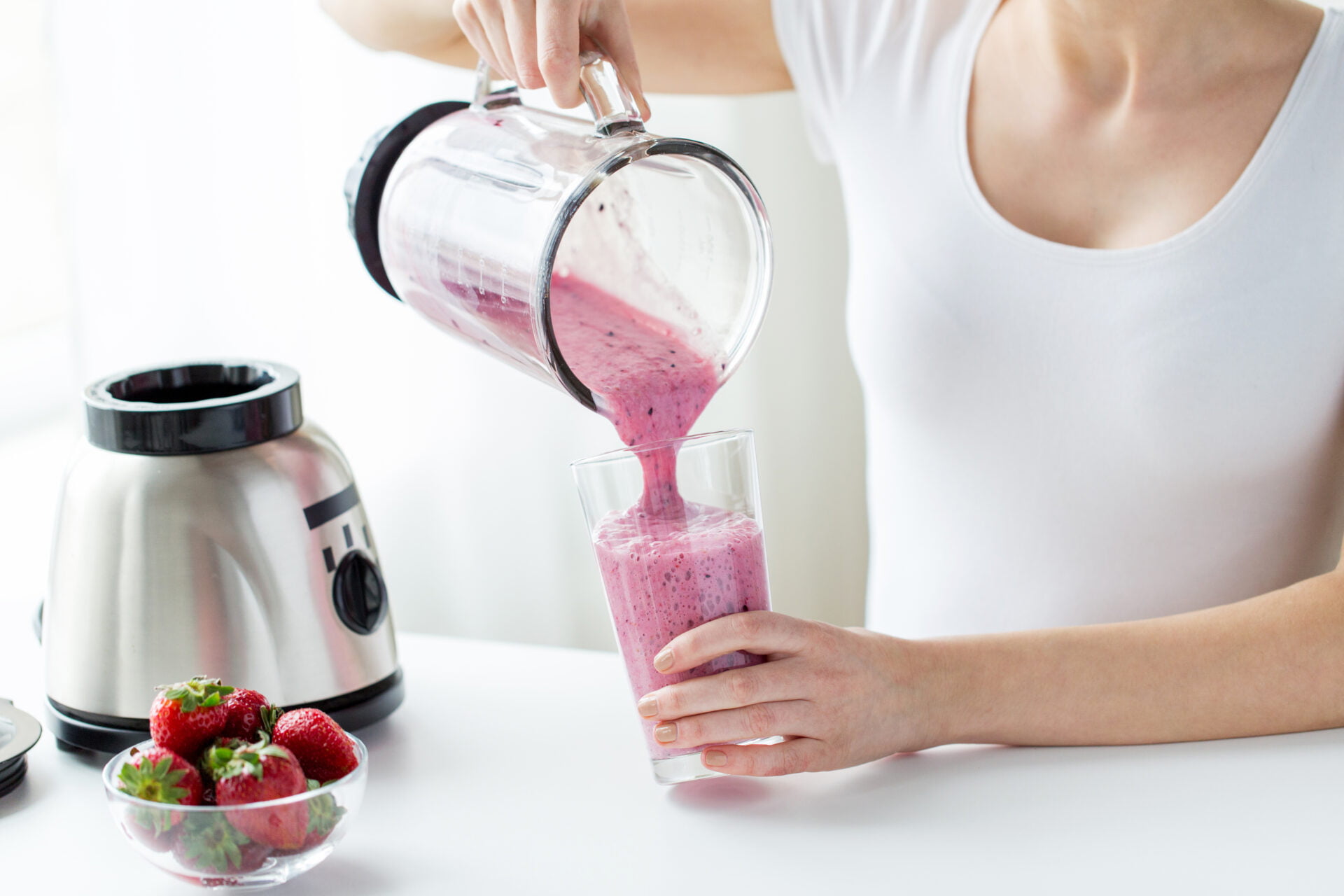 woman pouring smoothie out of non-toxic glass blender