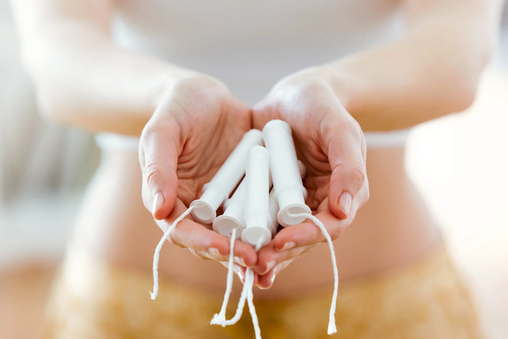 Close-up of the hands of a woman holding some tampons
