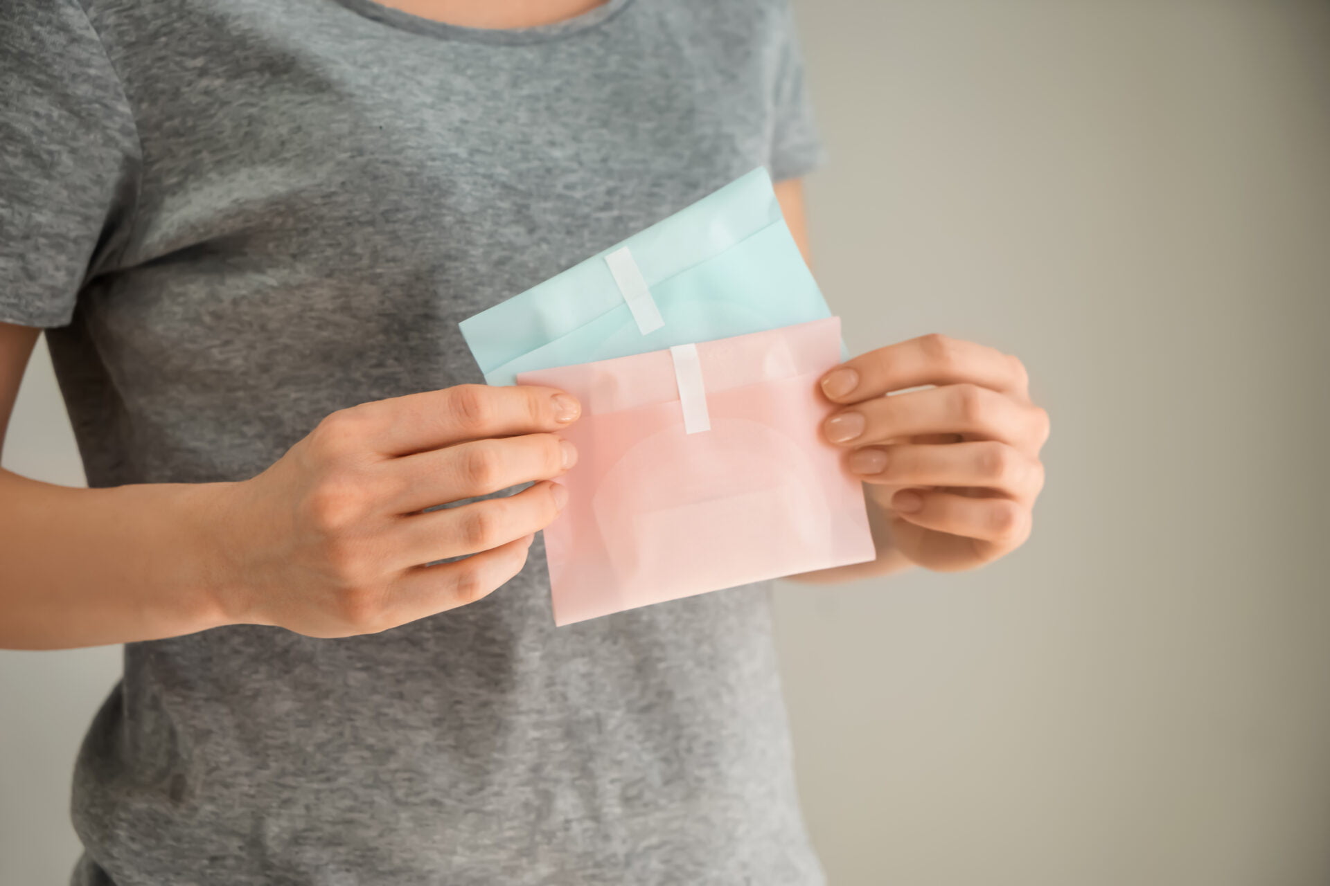 woman holding sanitary pads that could have PFAS "forever chemicals" inside