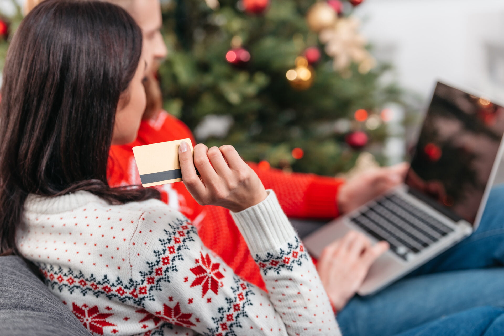 woman doing all her non-toxic holiday shopping online in front of the christmas tree