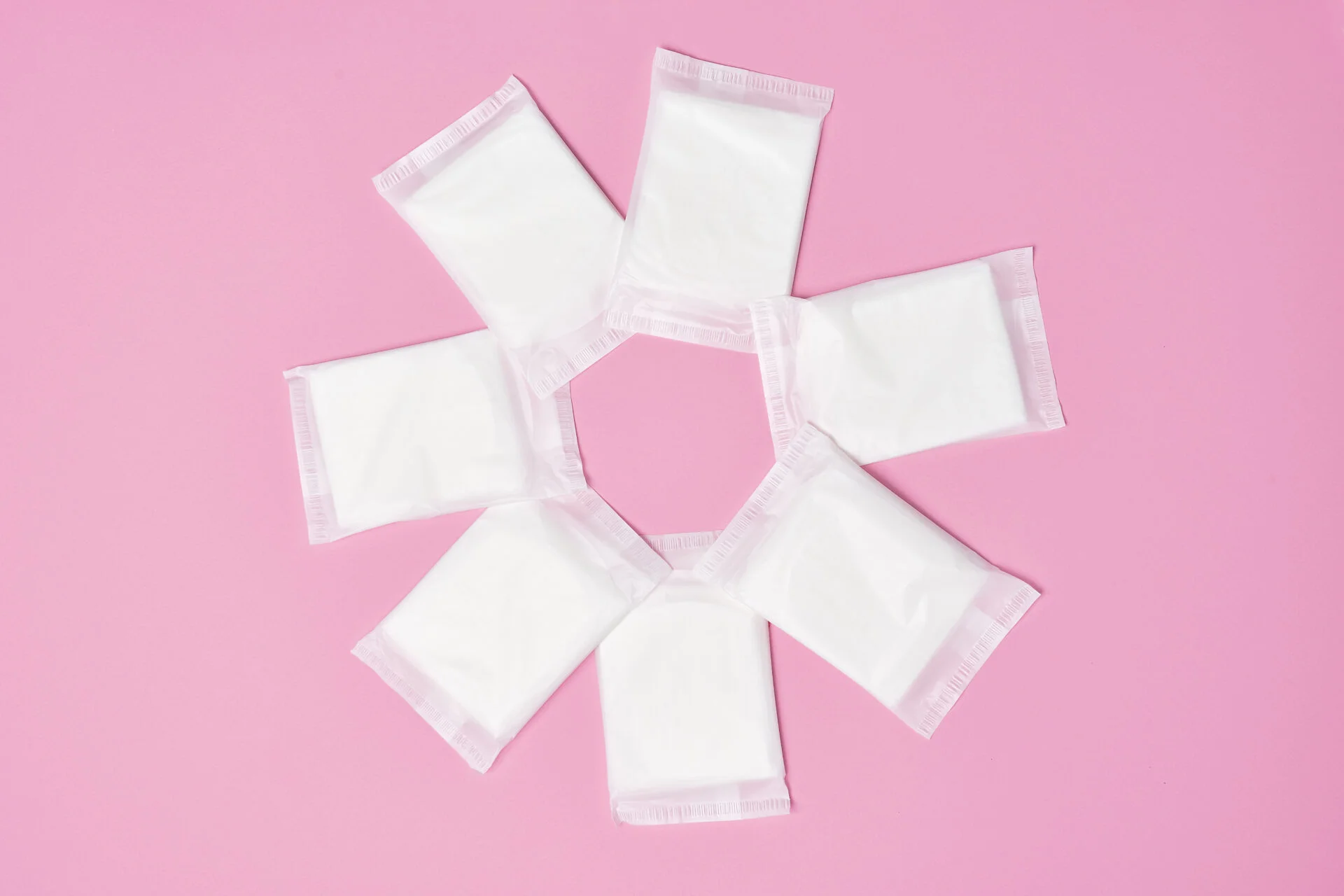 packaged cotton sanitary napkin pad on pink background
