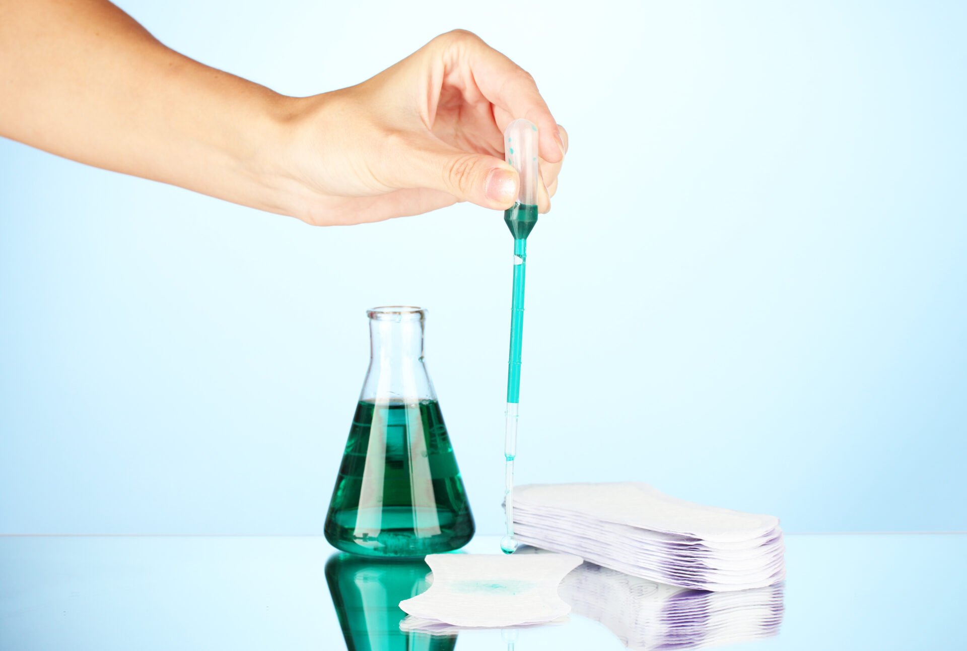 Testing sanitary pads for absorbency, on blue background close-up