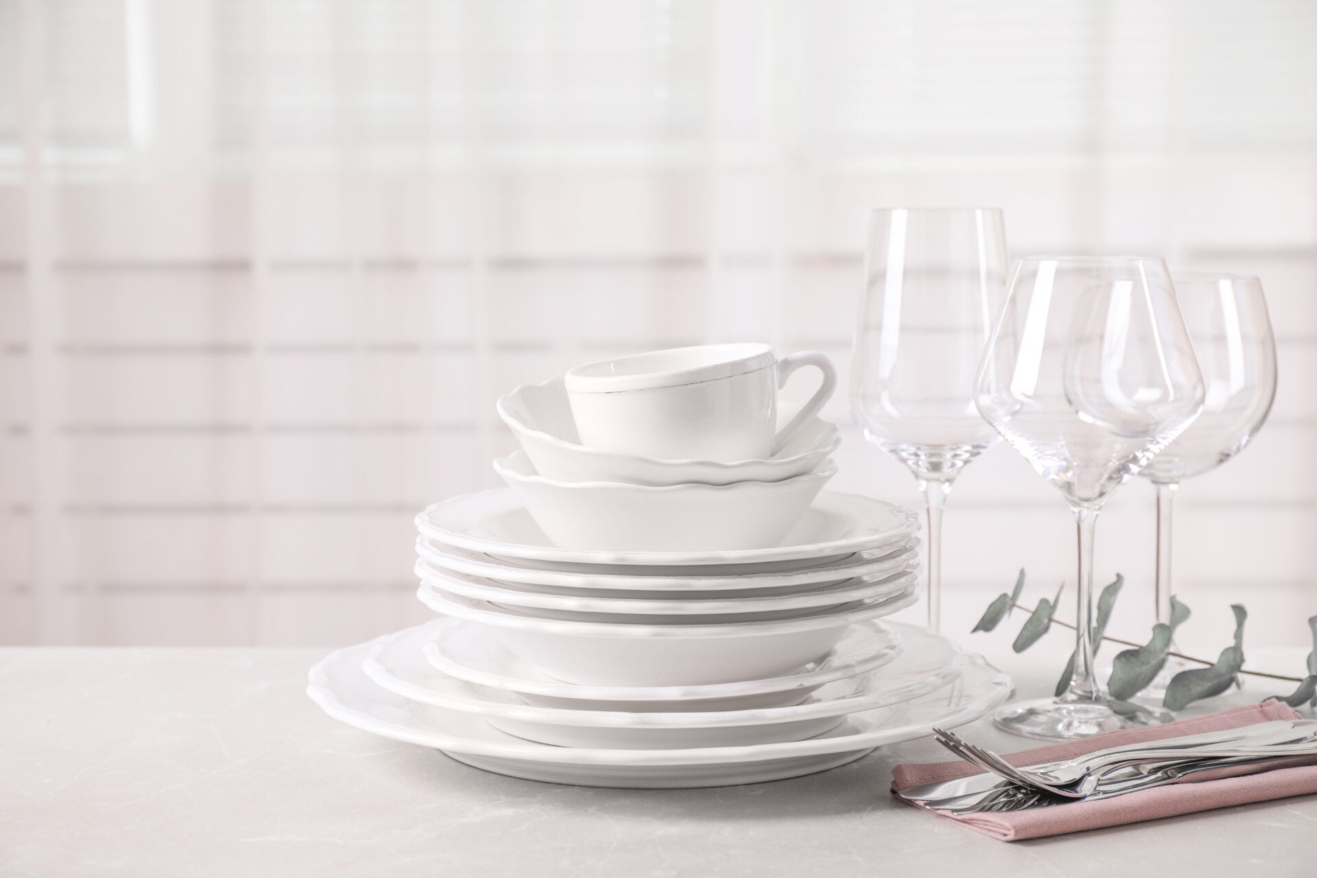 Set of clean tableware on light grey marble table