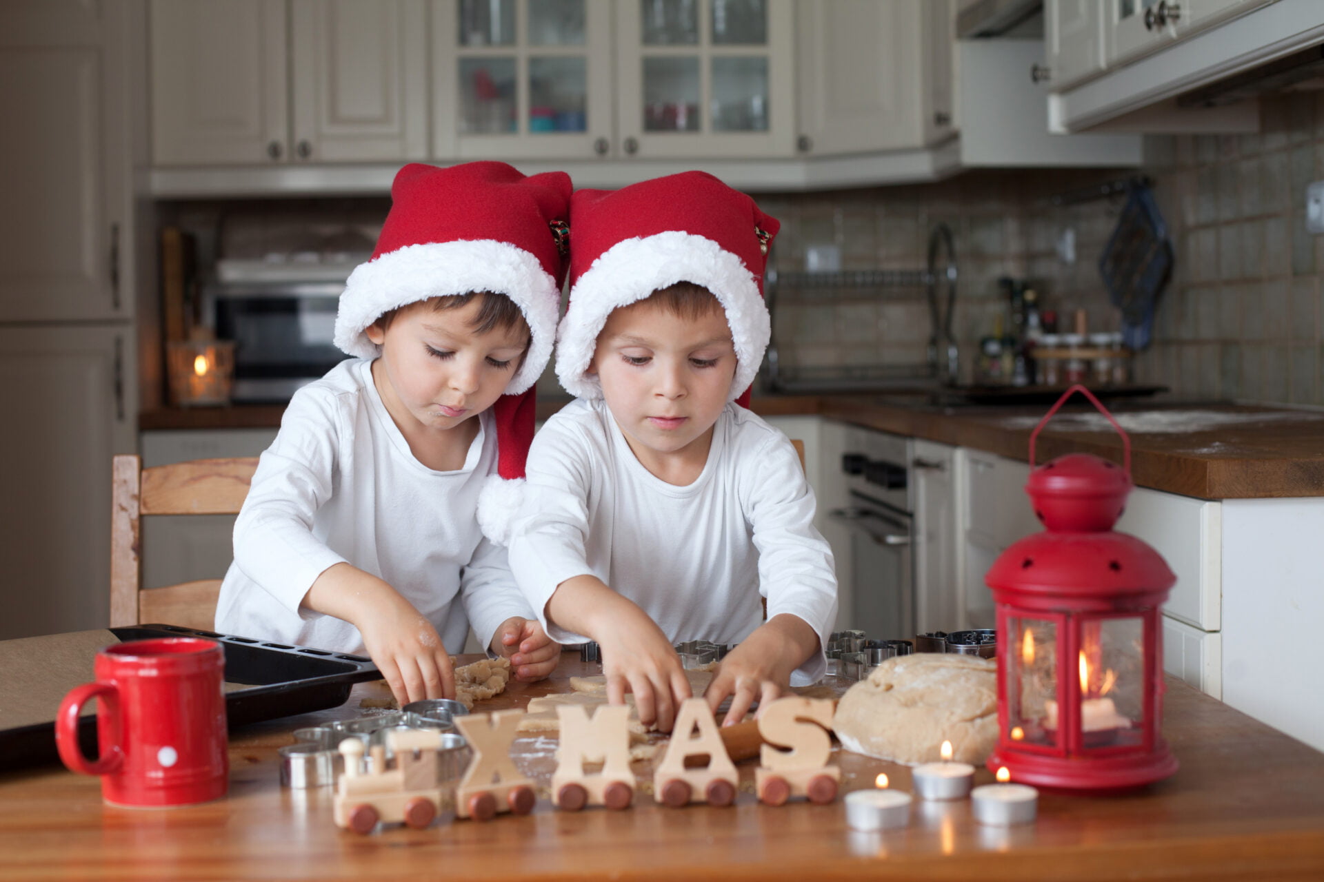 two boys in the kitchen making cooking before Christmas