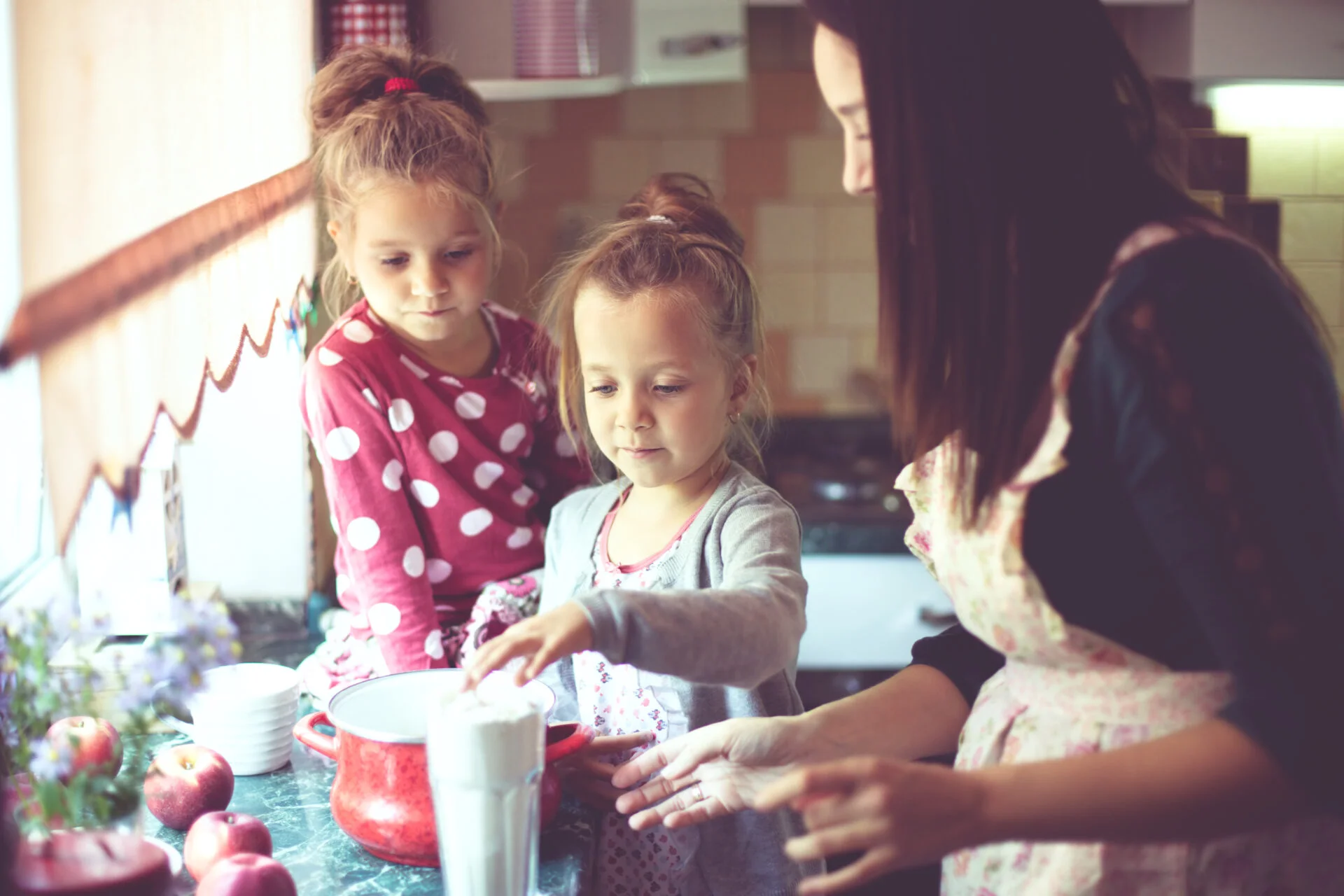 Mom with her two daughters cooking non-toxic holiday cookies