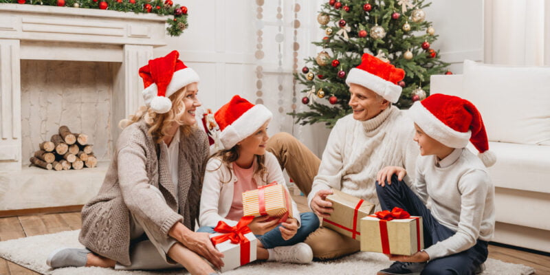Family gathered around the Christmas tree opening up non-toxic holiday gifts