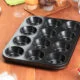Black 12 cup muffin tin on a table