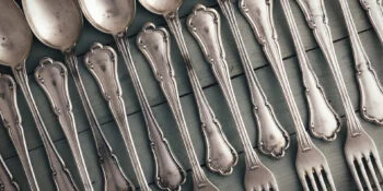 Set of antique silverware from spoons and forks on wooden table. Food concept background